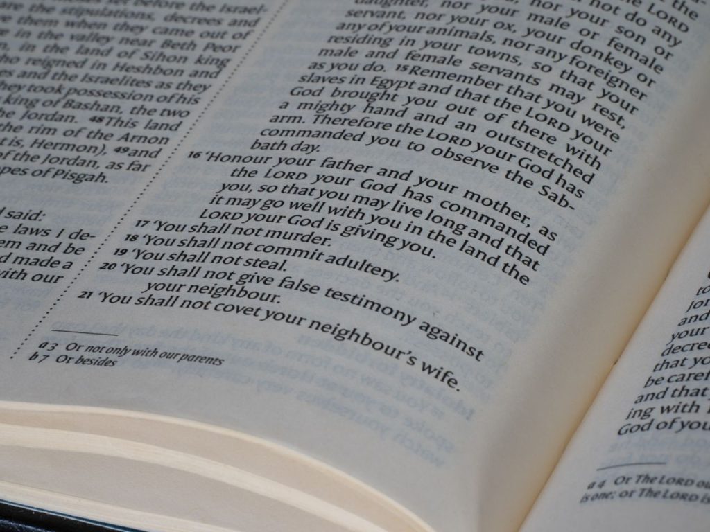The Art of Drawing Readers In: Your attractive post title goes here Detailed view of a Bible page showing the Ten Commandments text, ideal for religious and educational themes.
