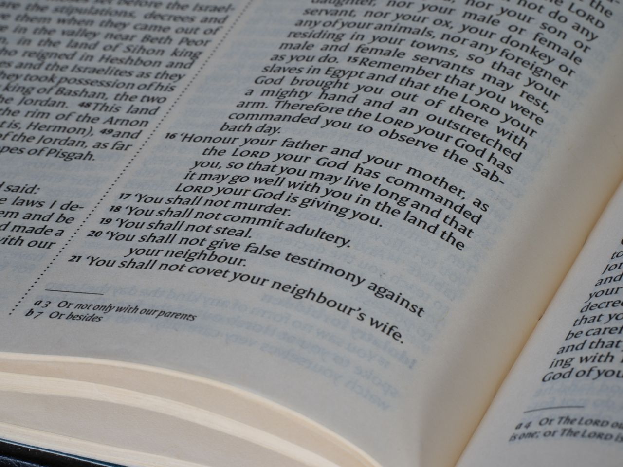 The Art of Drawing Readers In: Your attractive post title goes here Detailed view of a Bible page showing the Ten Commandments text, ideal for religious and educational themes.